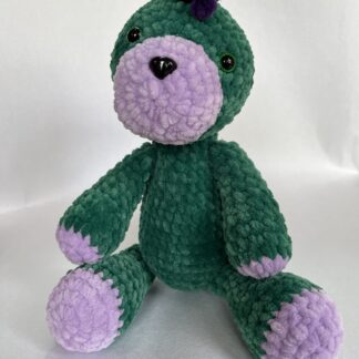 Ръчно плетен динозавър на една кука от зелена и лилава плюшена прежда отпред